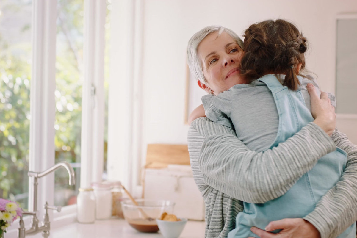 Grand-mère serrant sa petite-fille dans ses bras dans une cuisine