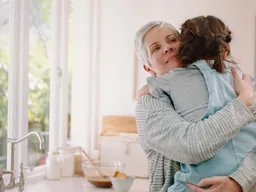 Grand-mère serrant sa petite-fille dans ses bras dans une cuisine